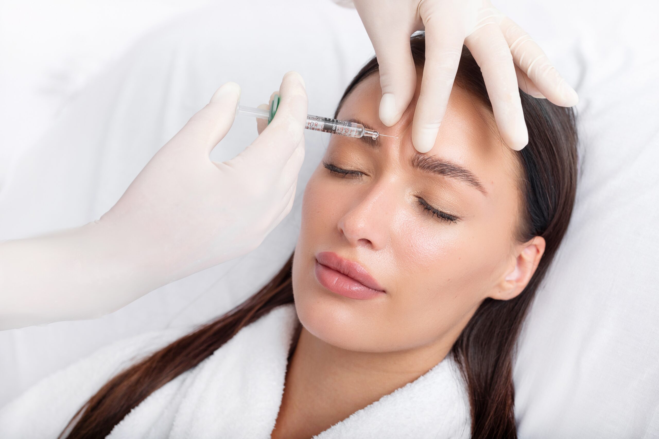 woman receiving Botox injection in her forehead