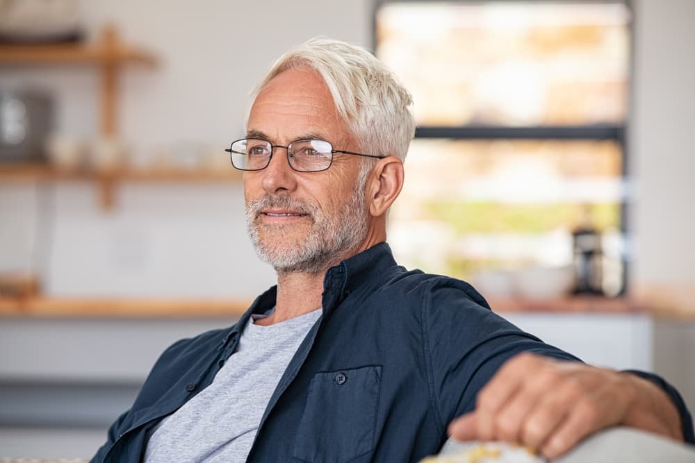 older man in glasses looking serious